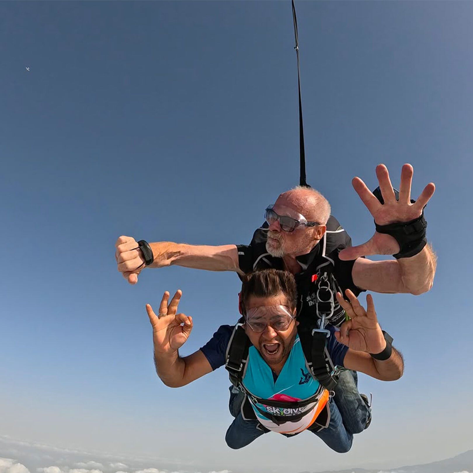 Tandem skydivers in freefall above the clouds on a jump in Rajasthan