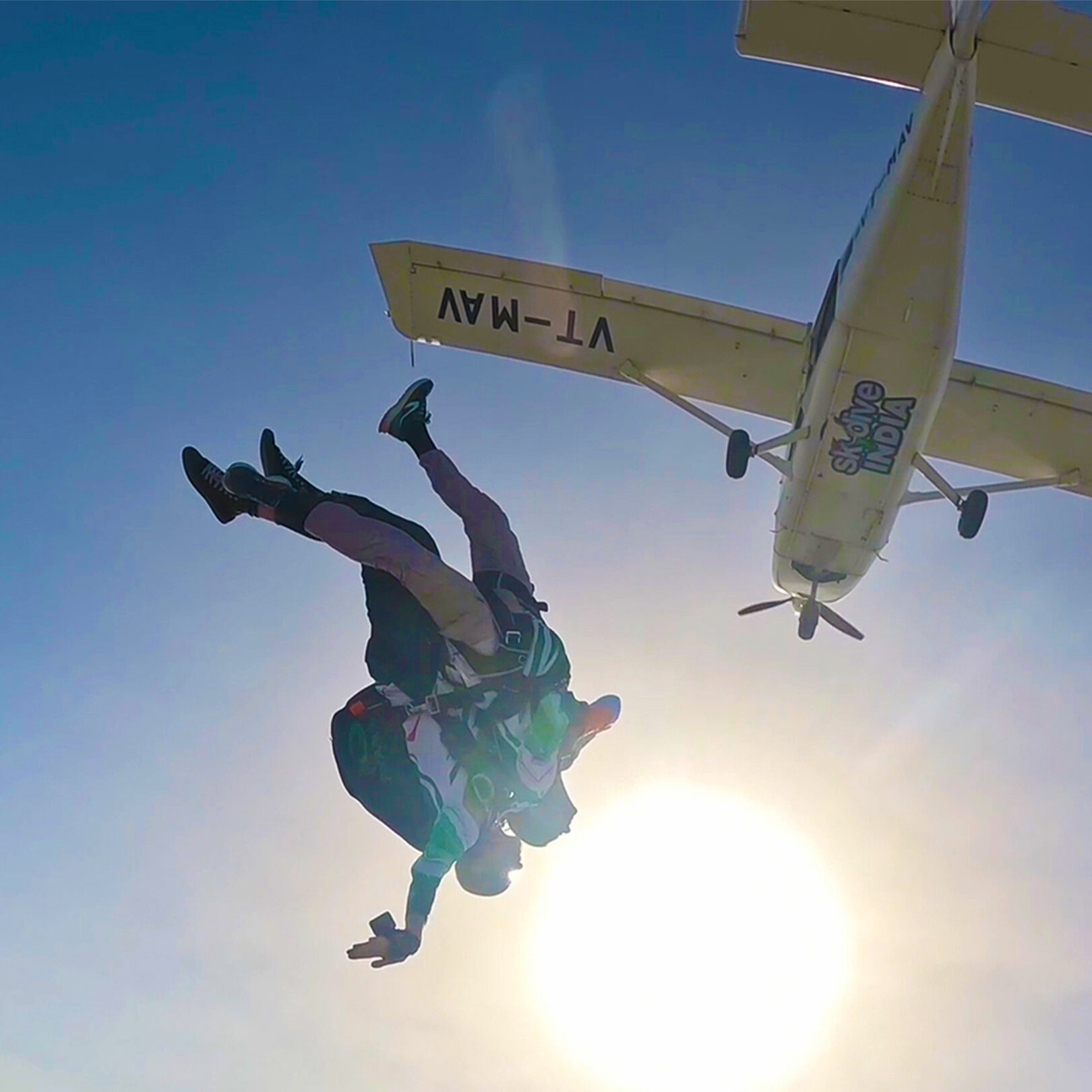Skydiver in freefall silhouetted against the sun after exiting over Rajasthan